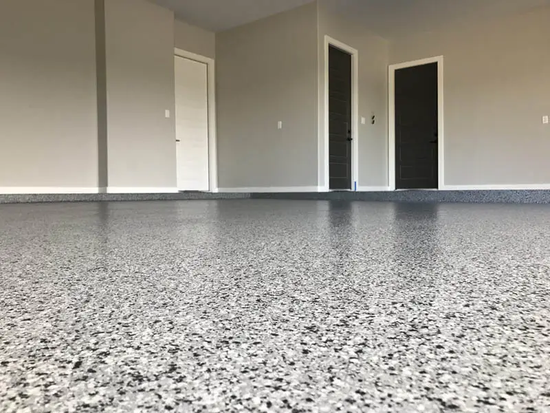 Epoxy flake floor coating in Knoxville TN — gray broadcast chip pattern in empty garage